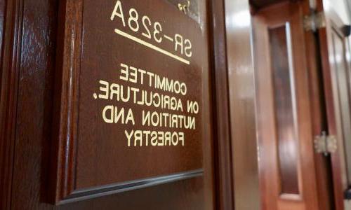 photo of a wall plaque made of dark wood with gold lettering that reads "SR-328A Committee on Agriculture, Nutrition and Forestry"